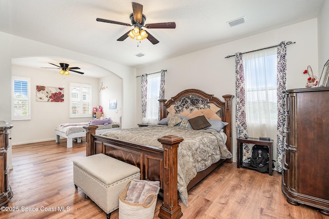 4109 Alligator Flag Cir, West Melbourne, FL 32904 - bedroom with light wood finished floors, multiple windows, arched walkways, and baseboards