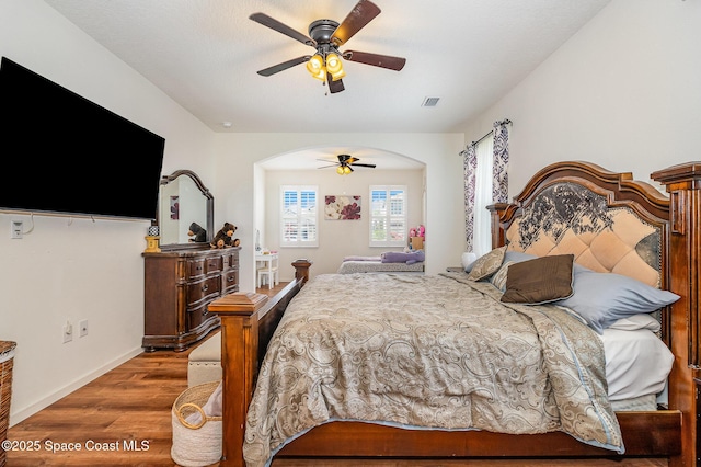 4109 Alligator Flag Cir, West Melbourne, FL 32904 - bedroom with wood finished floors, arched walkways, a ceiling fan, and baseboards