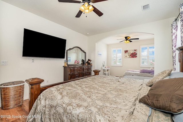 4109 Alligator Flag Cir, West Melbourne, FL 32904 - bedroom featuring arched walkways, wood finished floors, baseboards, and ceiling fan