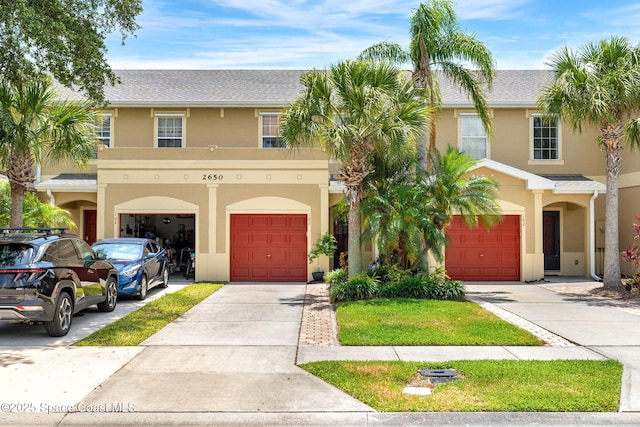 2650 Revolution St Unit 103, Melbourne, FL 32935 - townhome / multi-family property featuring stucco siding, an attached garage, and driveway