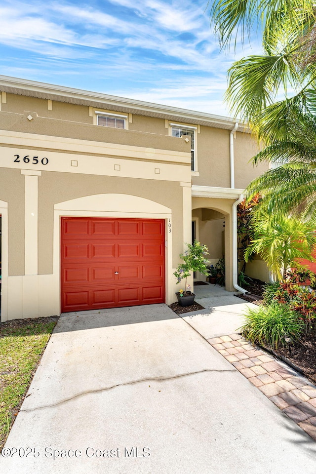 2650 Revolution St Unit 103, Melbourne, FL 32935 - view of front of house with stucco siding, driveway, and a garage