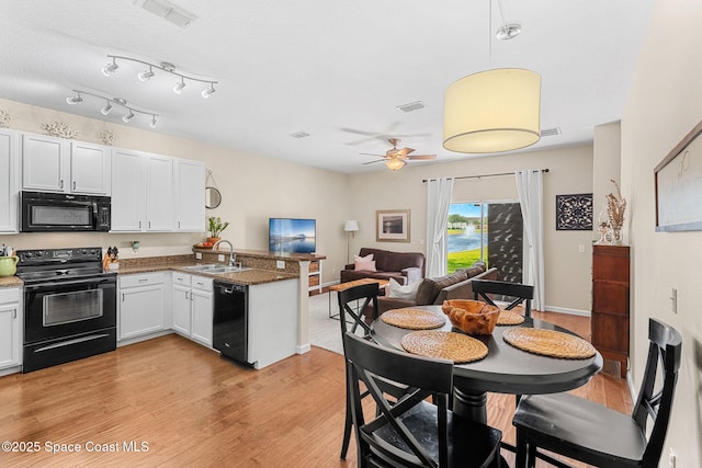 2650 Revolution St Unit 103, Melbourne, FL 32935 - kitchen featuring black appliances, a sink, a peninsula, a ceiling fan, and light wood-style floors