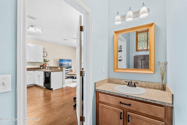 2650 Revolution St Unit 103, Melbourne, FL 32935 - bathroom featuring vanity, wood finished floors, and wine cooler