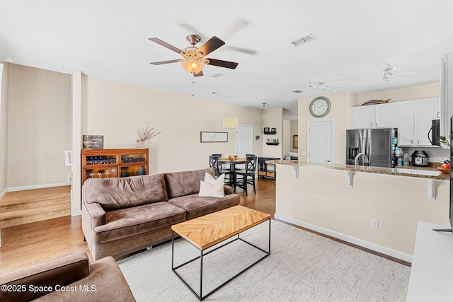 2650 Revolution St Unit 103, Melbourne, FL 32935 - living room with light wood-style floors, a ceiling fan, and baseboards