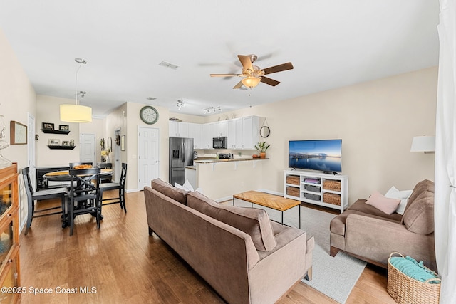 2650 Revolution St Unit 103, Melbourne, FL 32935 - living room with light wood-style floors, ceiling fan, and baseboards