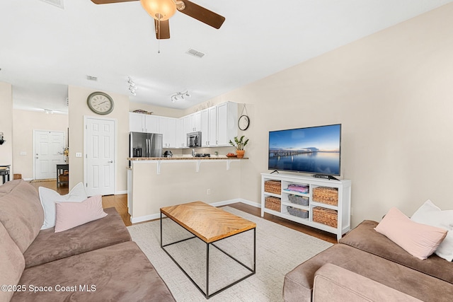 2650 Revolution St Unit 103, Melbourne, FL 32935 - living area with a ceiling fan, baseboards, and light wood-style flooring