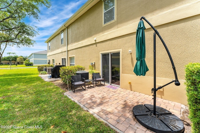 2650 Revolution St Unit 103, Melbourne, FL 32935 - back of property featuring a patio, stucco siding, a yard, and central AC