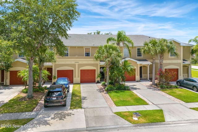 2650 Revolution St Unit 103, Melbourne, FL 32935 - townhome / multi-family property with a garage, driveway, and stucco siding