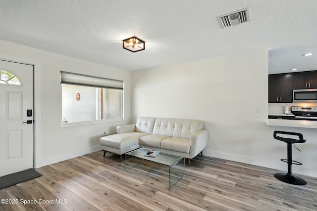 135 Richland Ave, Merritt Island, FL 32953 - living area with a textured ceiling, light wood-type flooring, and baseboards