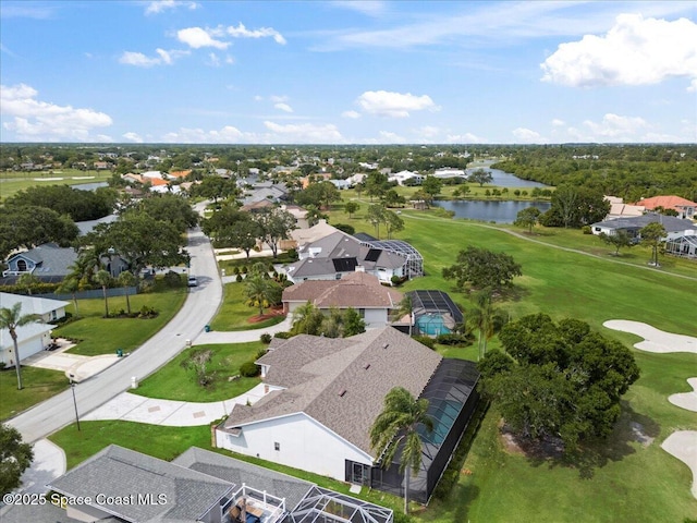 aerial perspective of suburban area with a nearby body of water and a golf course