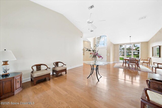 649 Spring Lake Dr, Melbourne, FL 32940 - living area with ceiling fan, light wood-style floors, lofted ceiling, baseboards, and a chandelier