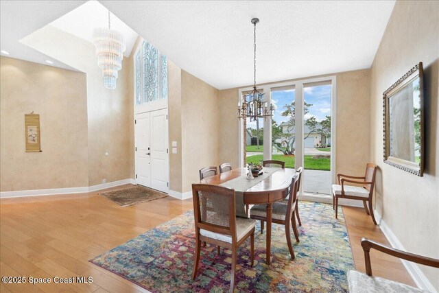 649 Spring Lake Dr, Melbourne, FL 32940 - dining area with a chandelier, wood finished floors, and baseboards