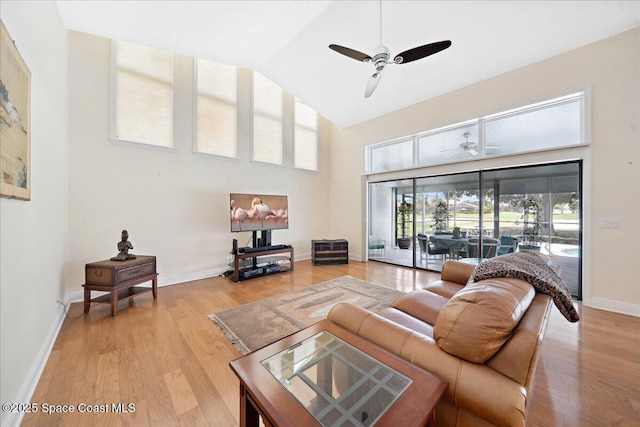 649 Spring Lake Dr, Melbourne, FL 32940 - living room with ceiling fan, high vaulted ceiling, light wood-style flooring, and baseboards