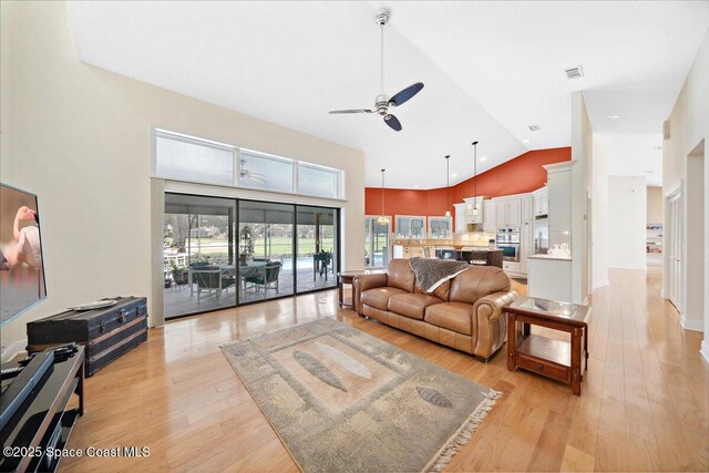 649 Spring Lake Dr, Melbourne, FL 32940 - living area featuring a ceiling fan, high vaulted ceiling, and light wood-style floors