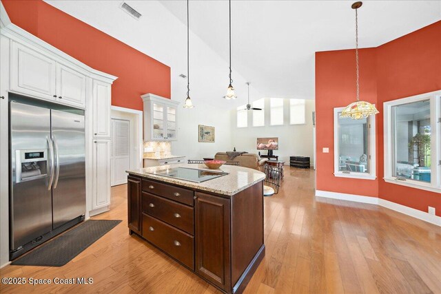 649 Spring Lake Dr, Melbourne, FL 32940 - kitchen featuring stainless steel refrigerator with ice dispenser, white cabinetry, dark brown cabinetry, glass insert cabinets, and black electric cooktop