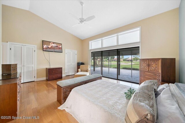 649 Spring Lake Dr, Melbourne, FL 32940 - bedroom featuring high vaulted ceiling, access to outside, light wood-style floors, baseboards, and two closets
