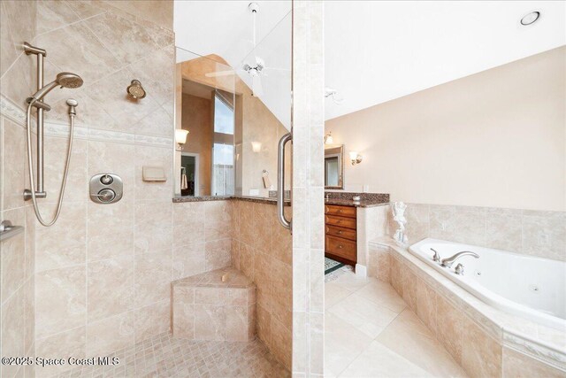 649 Spring Lake Dr, Melbourne, FL 32940 - bathroom featuring tiled shower, a jetted tub, and vanity