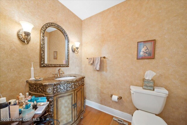 649 Spring Lake Dr, Melbourne, FL 32940 - bathroom with wood finished floors, toilet, baseboards, vanity, and vaulted ceiling