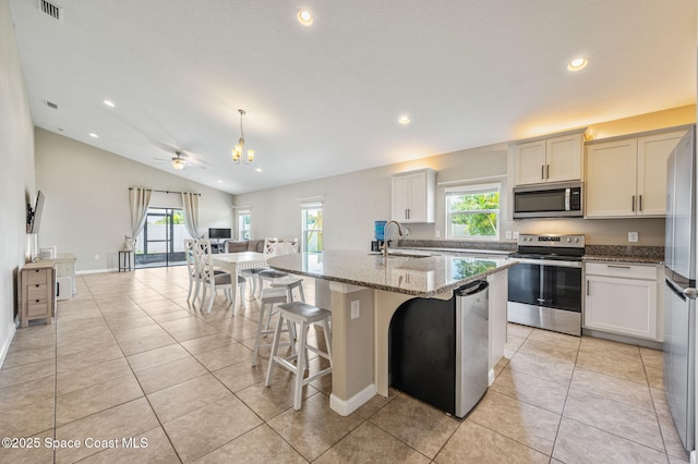 4065 Harvest Cir, Rockledge, FL 32955 - kitchen featuring appliances with stainless steel finishes, recessed lighting, plenty of natural light, light stone countertops, and a kitchen island with sink