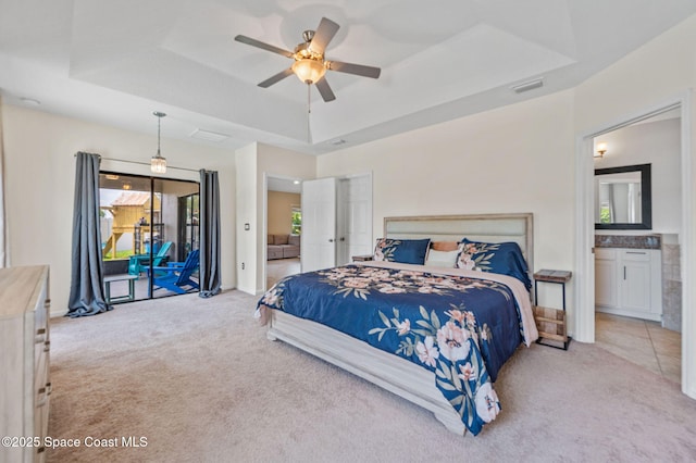 4065 Harvest Cir, Rockledge, FL 32955 - bedroom with carpet, a tray ceiling, access to exterior, and ensuite bathroom