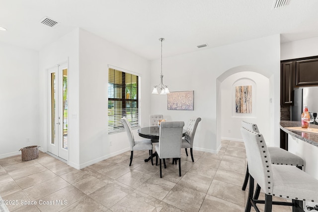 6794 Vista Hermosa Dr, Melbourne, FL 32940 - dining area featuring arched walkways, baseboards, a chandelier, and light tile patterned floors