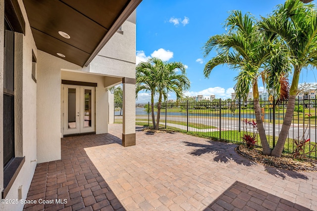 6794 Vista Hermosa Dr, Melbourne, FL 32940 - view of patio featuring french doors, a water view, and fence