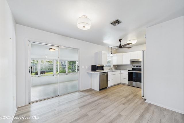 959 Eyerly Ln NE, Palm Bay, FL 32905 - kitchen featuring stainless steel appliances, white cabinetry, light countertops, light wood-style flooring, and ceiling fan