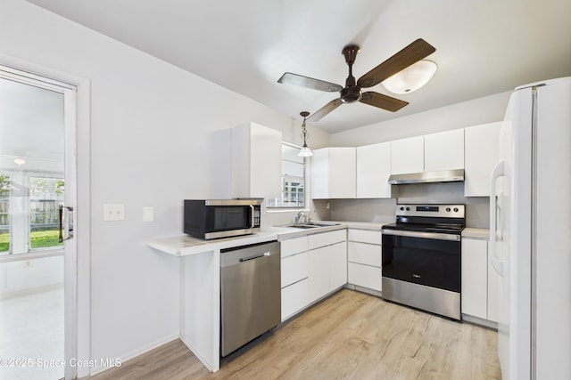 959 Eyerly Ln NE, Palm Bay, FL 32905 - kitchen with appliances with stainless steel finishes, under cabinet range hood, white cabinetry, light wood-style flooring, and ceiling fan
