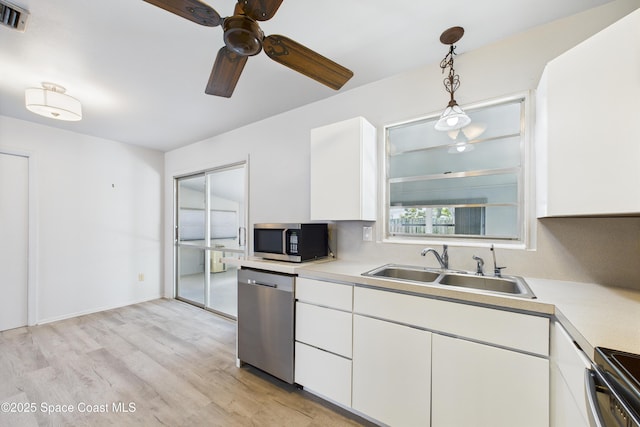 959 Eyerly Ln NE, Palm Bay, FL 32905 - kitchen with appliances with stainless steel finishes, ceiling fan, light countertops, light wood-style floors, and white cabinets