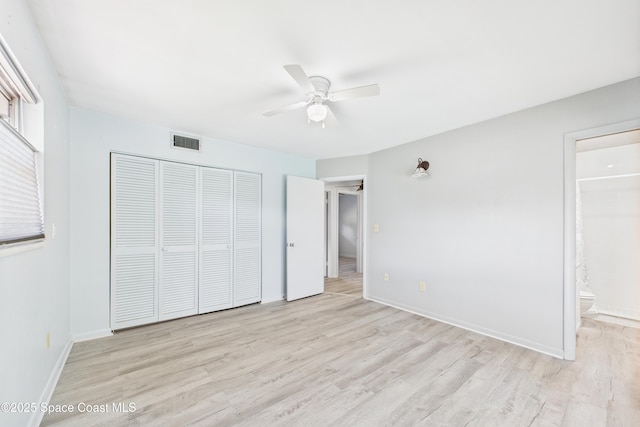 959 Eyerly Ln NE, Palm Bay, FL 32905 - unfurnished bedroom featuring light wood finished floors, a closet, ensuite bath, and ceiling fan