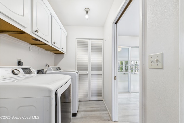 959 Eyerly Ln NE, Palm Bay, FL 32905 - laundry area with cabinet space, washer and clothes dryer, and light wood-type flooring