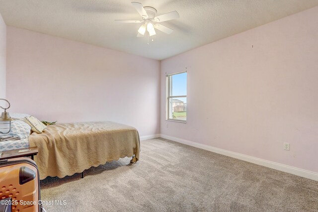 carpeted bedroom featuring baseboards and a ceiling fan