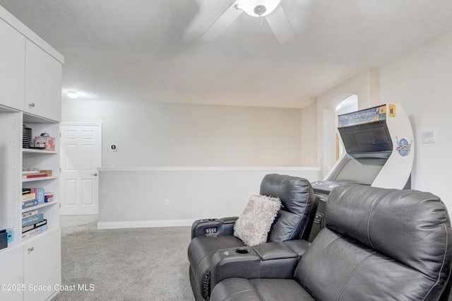 carpeted living area featuring a ceiling fan and baseboards