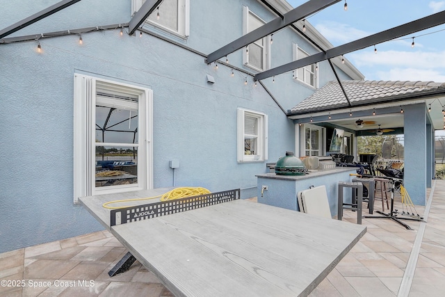 view of patio / terrace with outdoor dining area, an outdoor kitchen, and ceiling fan