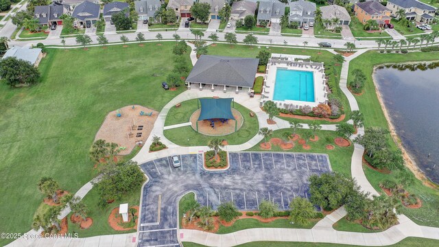 aerial view of property and surrounding area featuring a pool area and nearby suburban area