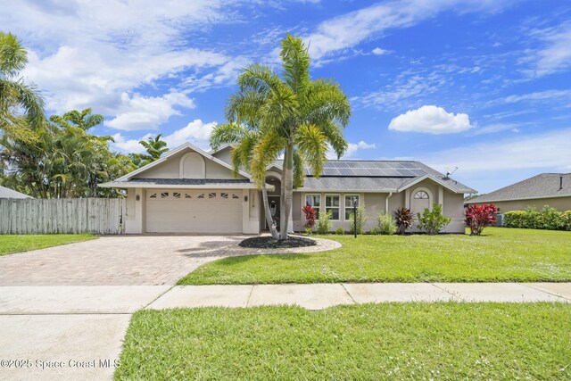 ranch-style house featuring driveway, an attached garage, stucco siding, and roof mounted solar panels