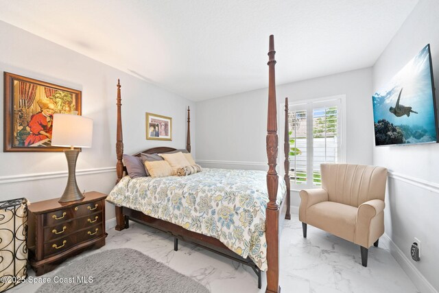 bedroom with marble finish floors and baseboards