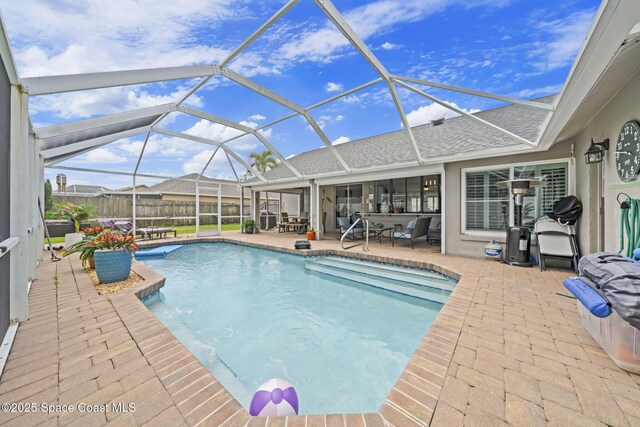 view of pool with a patio, glass enclosure, and fence