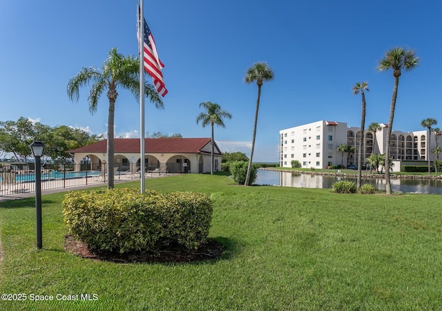 5807 N Atlantic Ave Unit 521, Cape Canaveral, FL 32920 - view of building exterior with a community pool, fence, and a water view