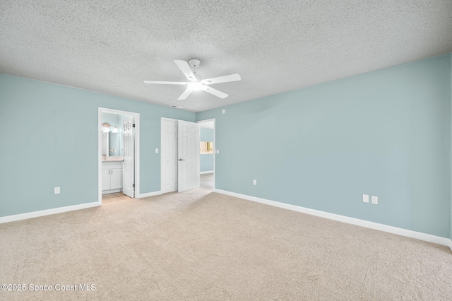5807 N Atlantic Ave Unit 521, Cape Canaveral, FL 32920 - unfurnished bedroom with light colored carpet, baseboards, ensuite bathroom, ceiling fan, and a textured ceiling