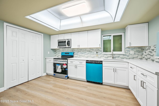 5807 N Atlantic Ave Unit 521, Cape Canaveral, FL 32920 - kitchen featuring stainless steel appliances, a sink, light countertops, and light wood-style flooring