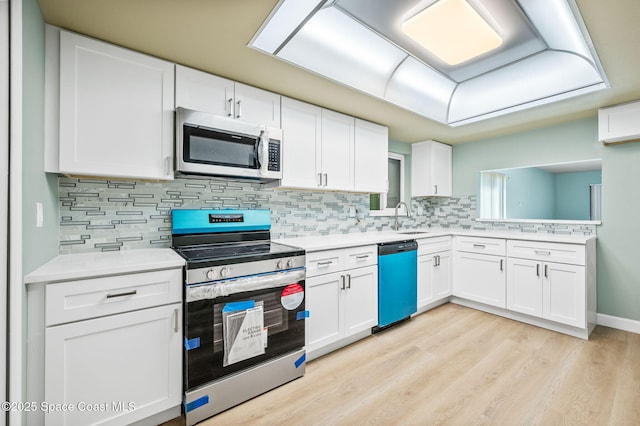 5807 N Atlantic Ave Unit 521, Cape Canaveral, FL 32920 - kitchen featuring stainless steel appliances, a sink, light countertops, white cabinets, and tasteful backsplash