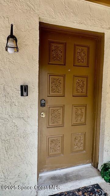 1648 S Park Ave, Titusville, FL 32780 - doorway to property featuring stucco siding and covered porch