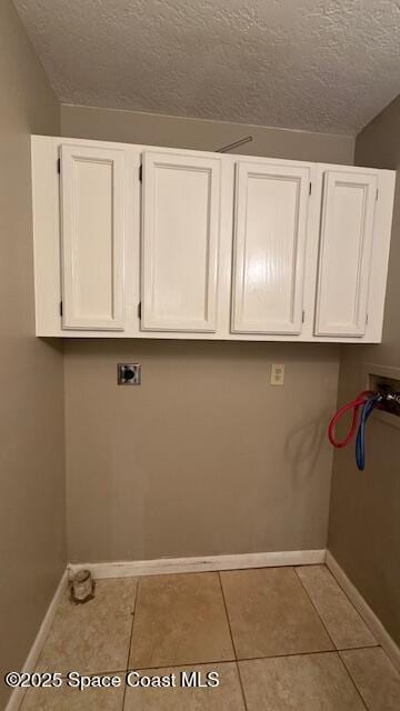 1648 S Park Ave, Titusville, FL 32780 - clothes washing area with cabinet space, washer hookup, baseboards, a textured ceiling, and tile patterned floors