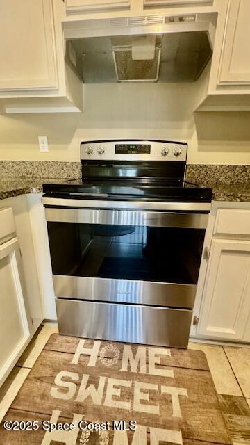 1648 S Park Ave, Titusville, FL 32780 - kitchen view of stainless steel electric range oven, under cabinet range hood, white cabinetry, and dark stone countertops