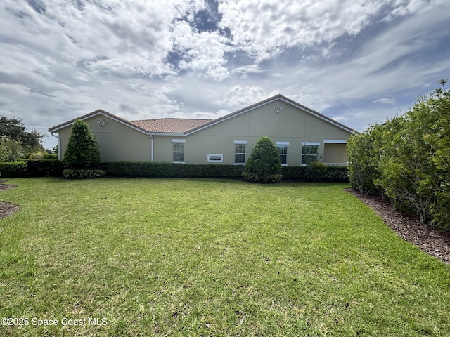 3455 Sedge Dr, Rockledge, FL 32955 - rear view of house with a lawn and a tiled roof
