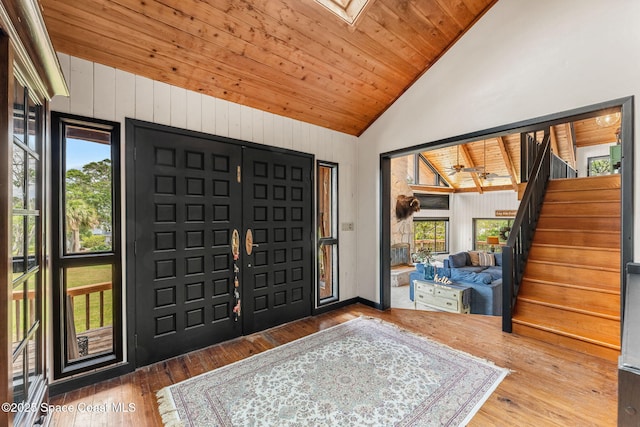 foyer featuring vaulted ceiling, stairs, wood-type flooring, and wood ceiling