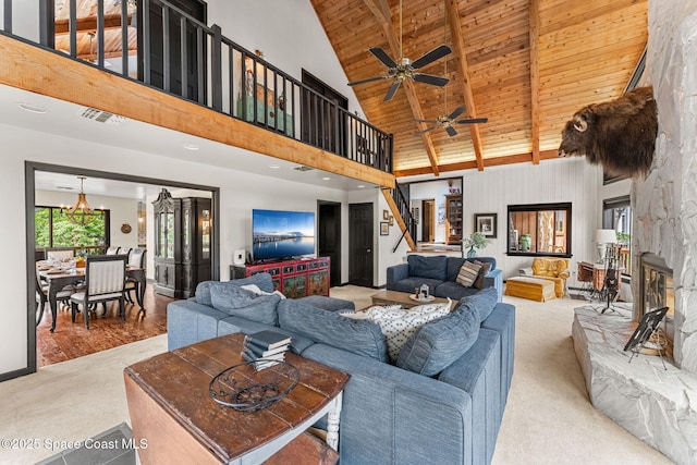 living area with stairway, wooden ceiling, carpet floors, high vaulted ceiling, and beamed ceiling