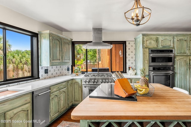 kitchen with green cabinets, island exhaust hood, plenty of natural light, and light countertops