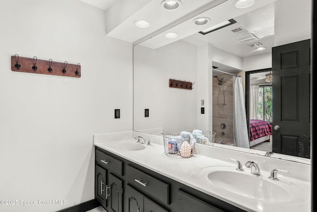 bathroom featuring a shower, double vanity, connected bathroom, baseboards, and recessed lighting
